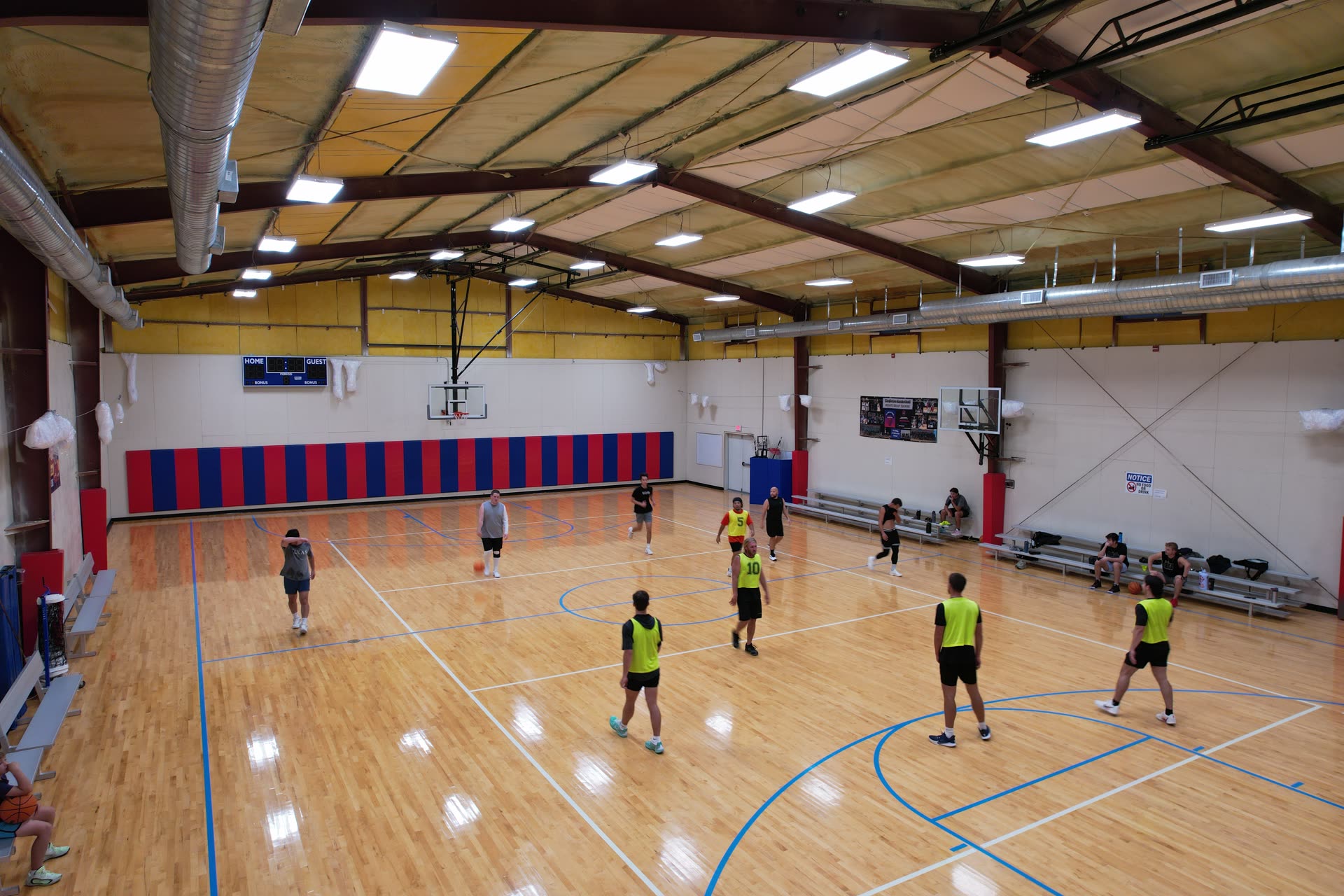 Wide view of a game on the full indoor court at Hilltop Court